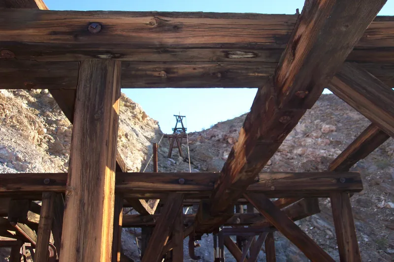 View of an aerial tramway tower through large wooden timbers.